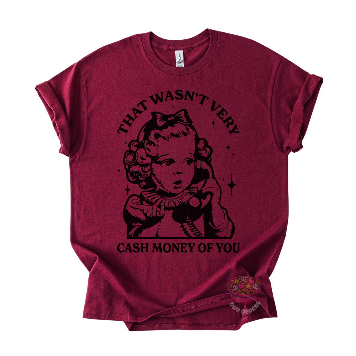 A maroon short-sleeve t-shirt with a black graphic print of a retro cartoon girl holding a phone, with the text 'THAT WASN'T VERY CASH MONEY OF YOU' on the front.
