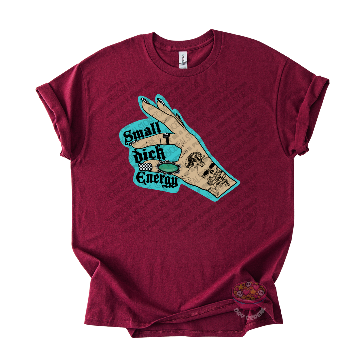 A maroon short-sleeve t-shirt with a graphic of a hand, overlaid with the text 'Small dick Energy' in a teal and black retro font.