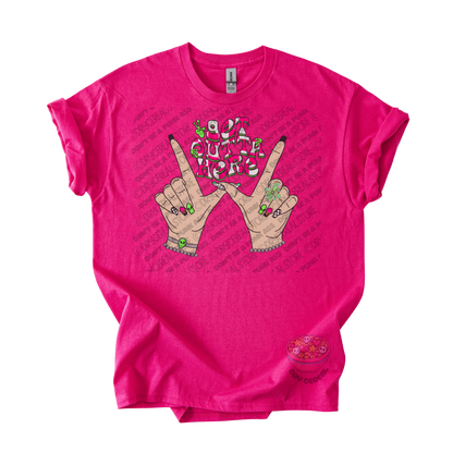 Hot pink unisex T-shirt featuring the phrase "Get Outta Here" above Y2K-inspired hands making the iconic gesture with colorful nails, alien accents, bracelets, and retro lettering.