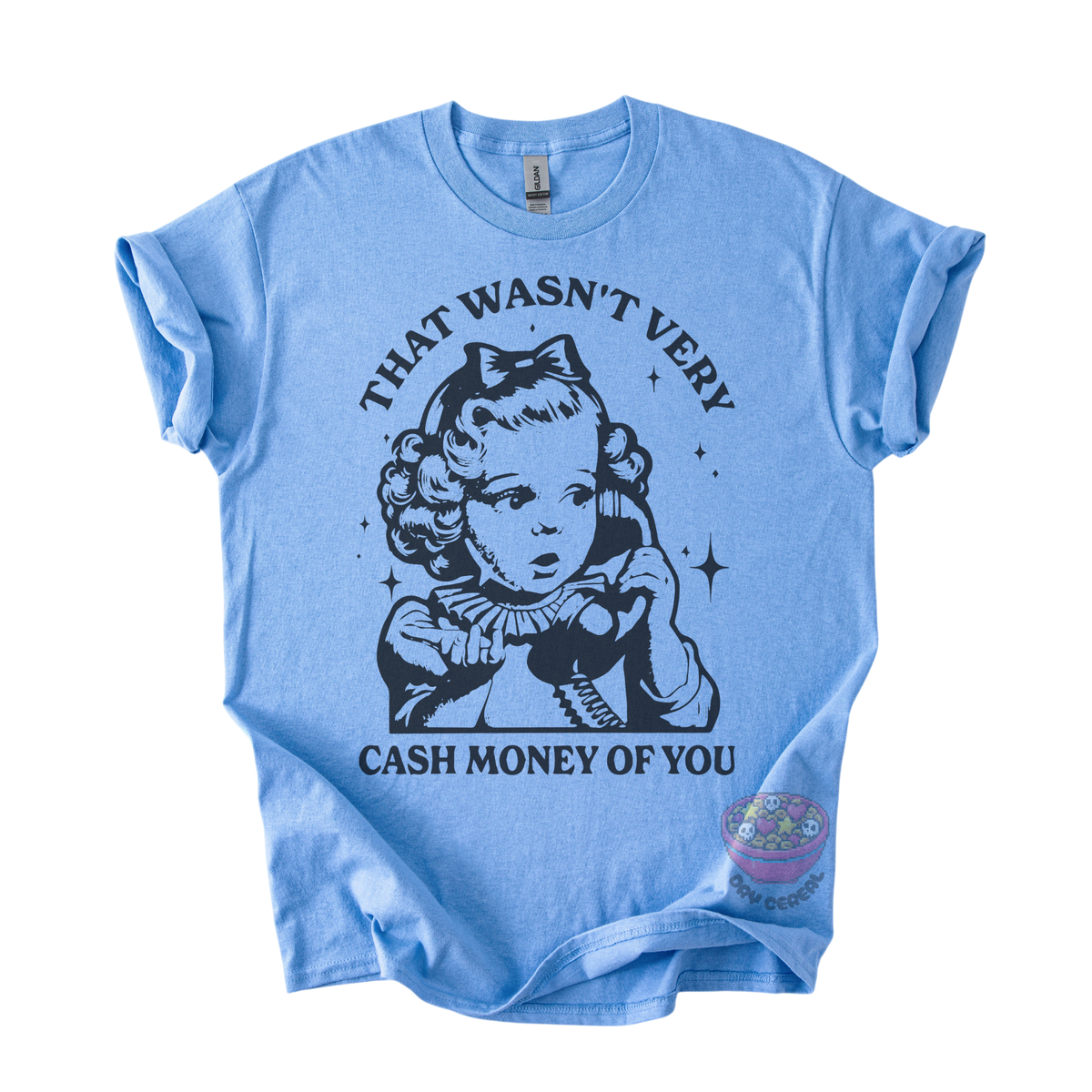 A light blue short-sleeve t-shirt with a black graphic print of a vintage-style cartoon girl holding a telephone, with the text 'THAT WASN'T VERY CASH MONEY OF YOU' printed around her. 