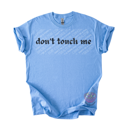 Light blue unisex tee featuring the phrase "don't touch me" in bold gothic black lettering across the chest.