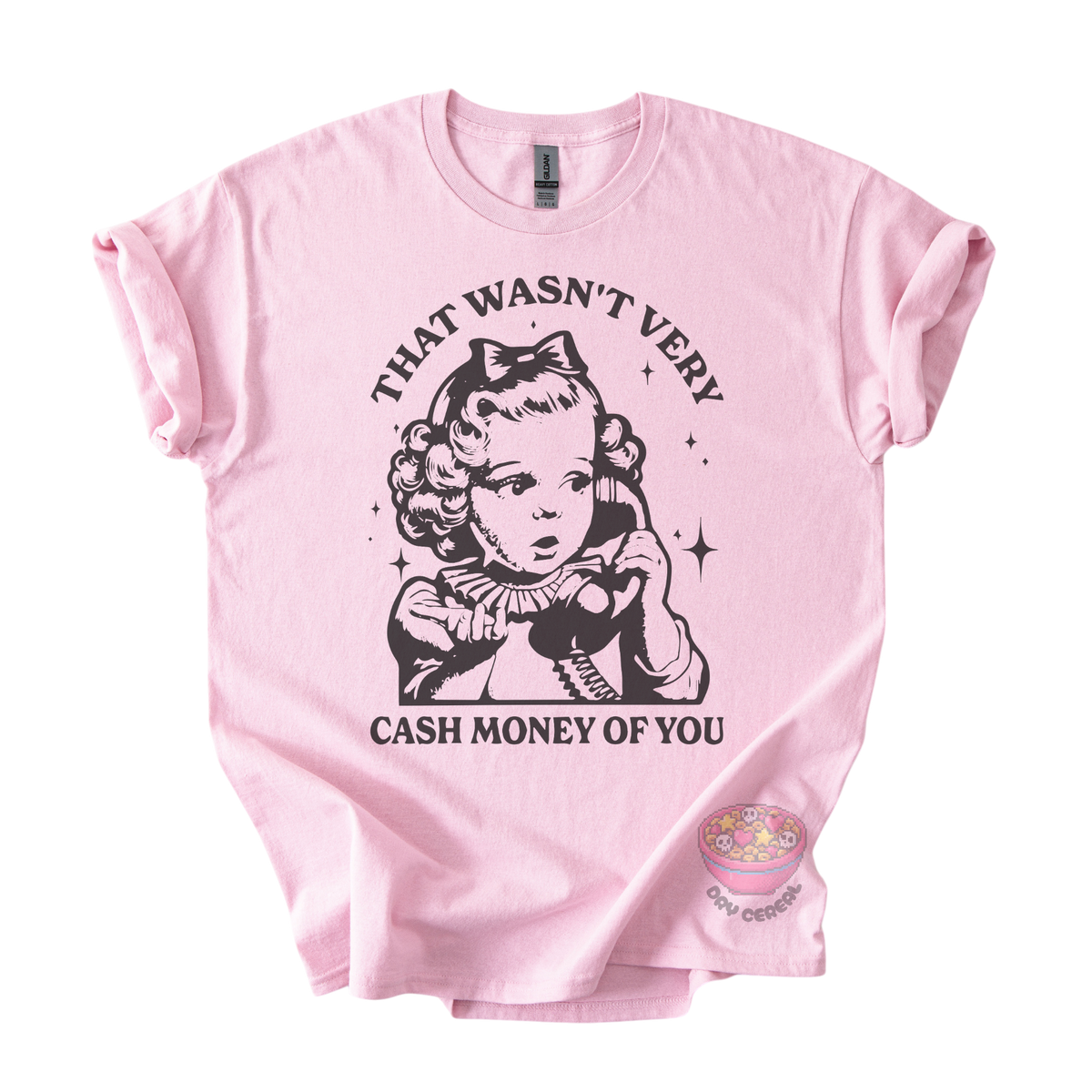 A light pink short-sleeve t-shirt with a black graphic print of a retro-style young girl holding a telephone, accompanied by the text 'THAT WASN'T VERY CASH MONEY OF YOU'. 