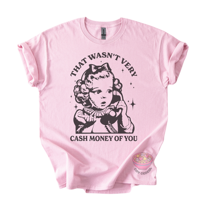 A light pink short-sleeve t-shirt with a black graphic print of a retro-style young girl holding a telephone, accompanied by the text 'THAT WASN'T VERY CASH MONEY OF YOU'. 