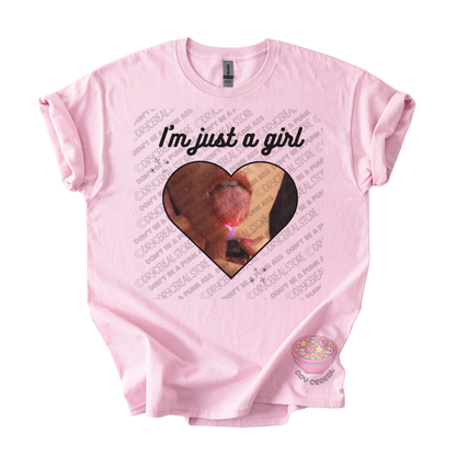 Light pink unisex T-shirt featuring the phrase "I'm just a girl" above an original heart-shaped collage graphic with an edgy alternative aesthetic