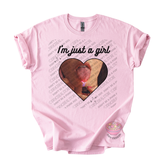 Light pink unisex T-shirt featuring the phrase "I'm just a girl" above an original heart-shaped collage graphic with an edgy alternative aesthetic
