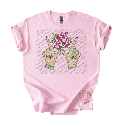 Light pink unisex T-shirt featuring the phrase "Get Outta Here" above Y2K-inspired hands making the iconic gesture with colorful nails, alien accents, bracelets, and retro lettering.