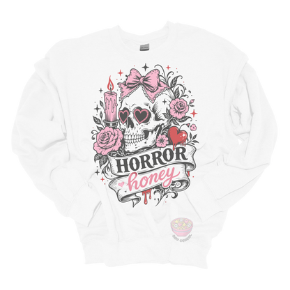 White crewneck sweatshirt featuring a vintage skull with heart-shaped sunglasses, pink bow, roses, candle, dripping heart, and the phrase "Horror Honey" in a spooky gothic design.