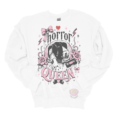 White crewneck sweatshirt featuring a horror-inspired long-haired ghost emerging from a television, surrounded by pink bows, roses, pearls, lightning bolts, and the phrase "Horror Queen."
