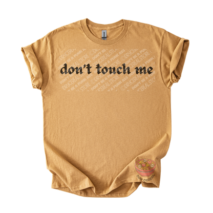 Gold unisex tee featuring the phrase "don't touch me" in bold gothic black lettering across the chest.