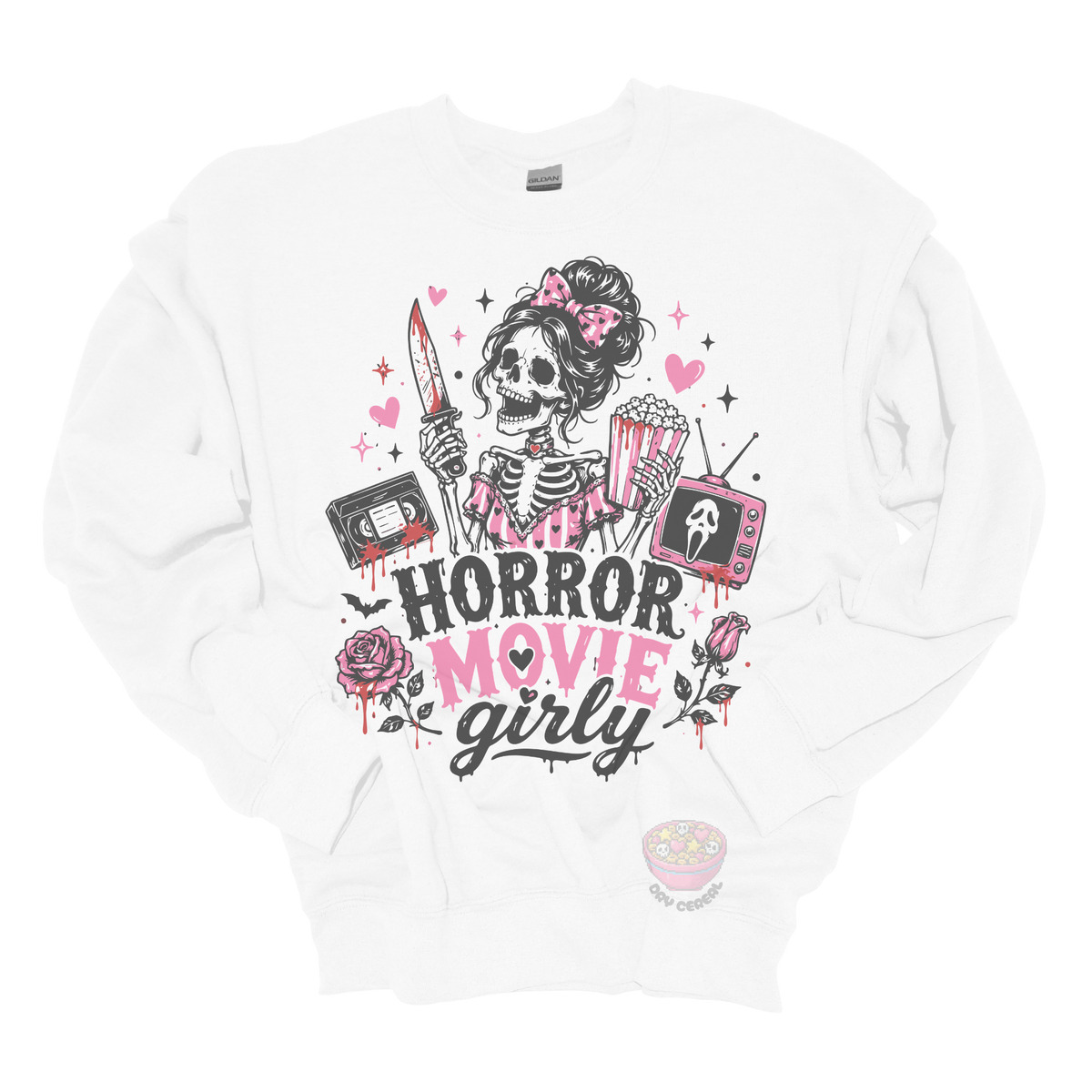 White crewneck sweatshirt featuring a skeleton with a pink bow holding a bloody knife and popcorn, surrounded by horror-inspired movie details, roses, hearts, a VHS tape, retro television, and the phrase "Horror Movie Girly."