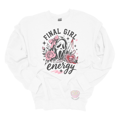 White crewneck sweatshirt featuring a horror-inspired ghost mask design with pink roses, a bloody knife, heart locket, lipstick, and the phrase "Final Girl Energy."