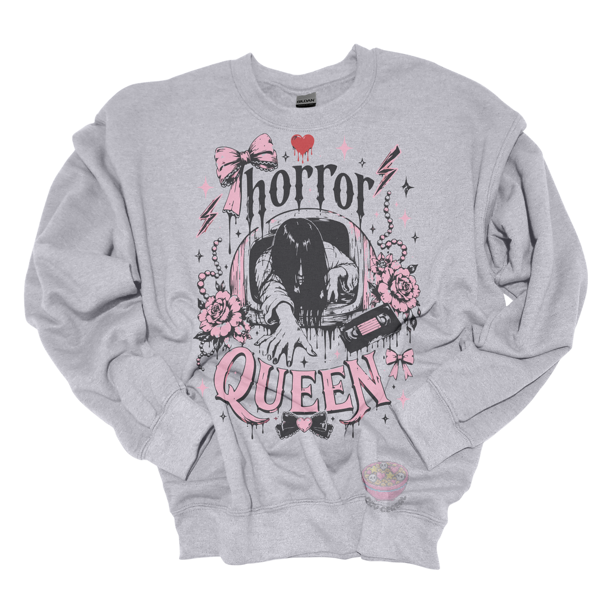 gray crewneck sweatshirt featuring a horror-inspired long-haired ghost emerging from a television, surrounded by pink bows, roses, pearls, lightning bolts, and the phrase "Horror Queen."