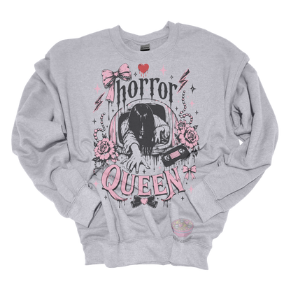 gray crewneck sweatshirt featuring a horror-inspired long-haired ghost emerging from a television, surrounded by pink bows, roses, pearls, lightning bolts, and the phrase "Horror Queen."