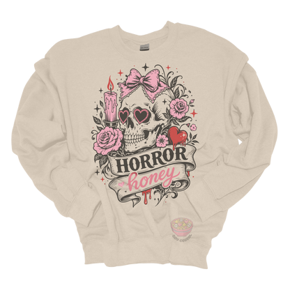 Beige crewneck sweatshirt featuring a vintage skull with heart-shaped sunglasses, pink bow, roses, candle, dripping heart, and the phrase "Horror Honey" in a spooky gothic design.