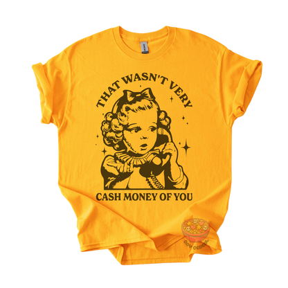 A bright yellow short-sleeve t-shirt with a black graphic print of a vintage-style cartoon girl holding a phone, with the text 'THAT WASN'T VERY CASH MONEY OF YOU' printed around the design.