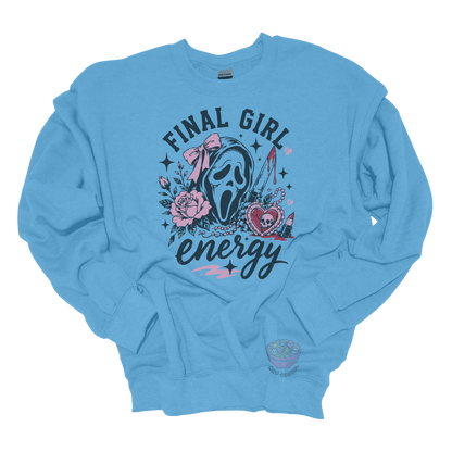 Light blue crewneck sweatshirt featuring a horror-inspired ghost mask design with pink roses, a bloody knife, heart locket, lipstick, and the phrase "Final Girl Energy."