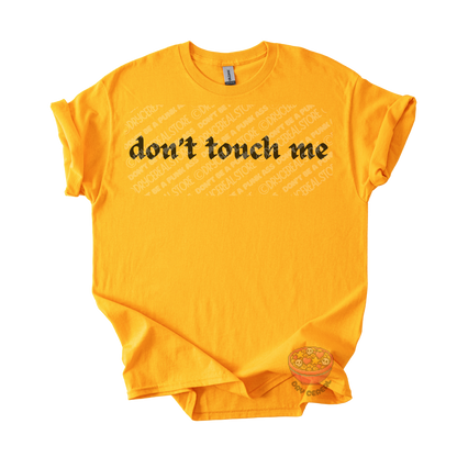 Gold unisex tee featuring the phrase "don't touch me" in bold gothic black lettering across the chest.