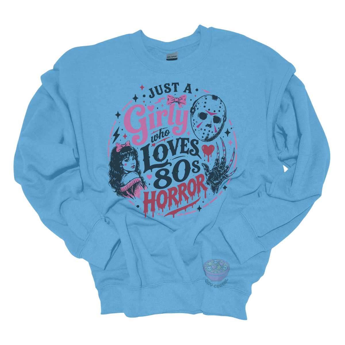 Light blue crewneck sweatshirt featuring the phrase "Just a Girly Who Loves 80s Horror" with retro horror-inspired artwork including a hockey mask, clawed glove, vintage girl illustration, pink bows, and spooky accents.