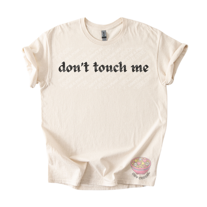 Natural unisex tee featuring the phrase "don't touch me" in bold gothic black lettering across the chest.