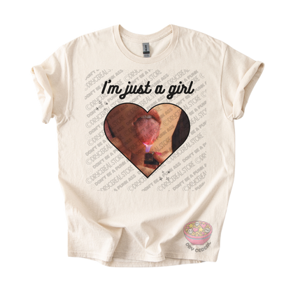 Natural unisex T-shirt featuring the phrase "I'm just a girl" above an original heart-shaped collage graphic with an edgy alternative aesthetic