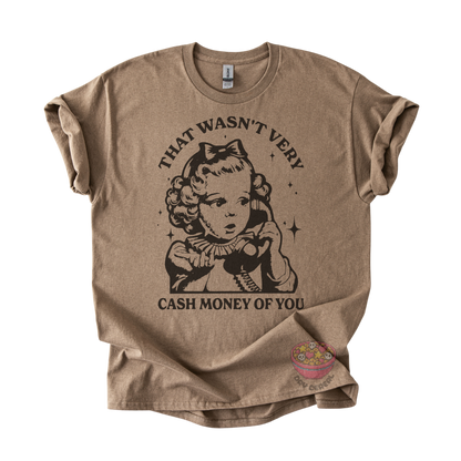 A brown graphic t-shirt featuring a vintage-style illustration of a girl with a bow and the text 'THAT WASN'T VERY CASH MONEY OF YOU'.