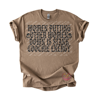 A brown graphic t-shirt with a distressed black text print that reads 'WOMEN PUTTING OTHER WOMEN DOWN IS STANK COOCHE ENERGY'. The t-shirt is laid flat against a white background.